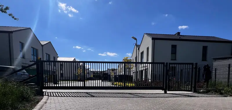 Brama przesuwna z pionowych profili i podjazd z kostki