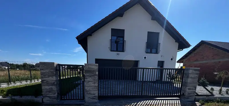 Front posesji z ogrodzeniem z pionowych profili