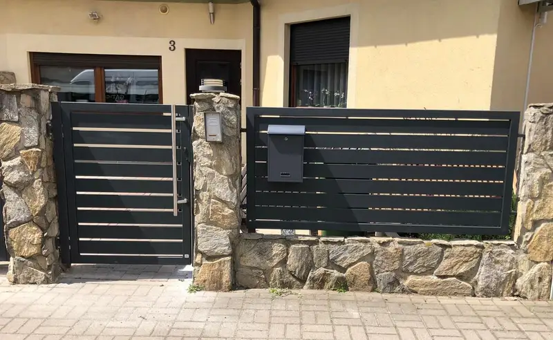 Furtka ze skrzynką na listy przy murku z kamienia