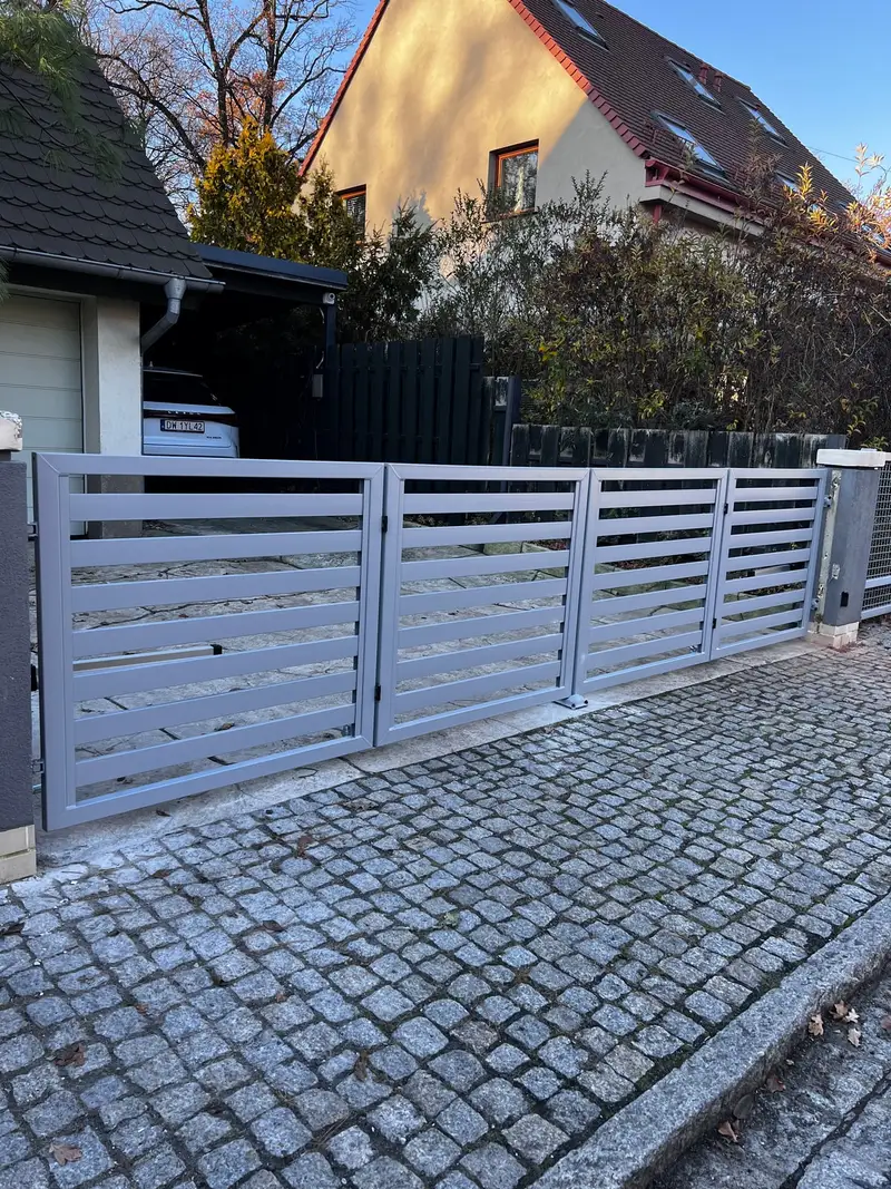 Szare ogrodzenie wzdłuż ulicy z kostki